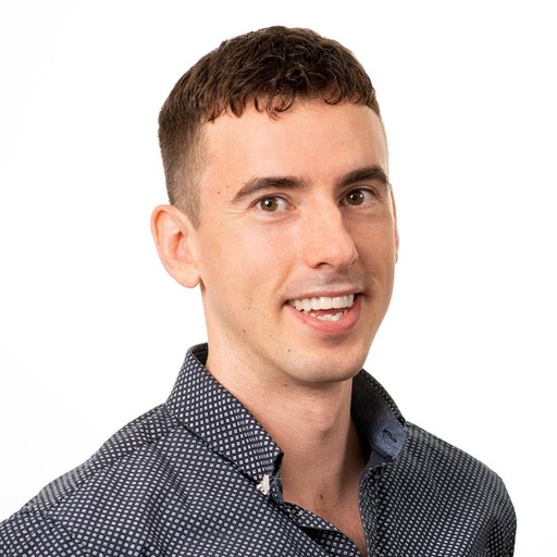 portrait photo of Jonathan smiling in blue shirt